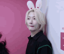 a man wearing bunny ears and a black shirt