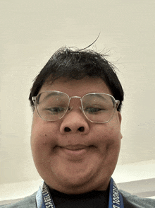 a man wearing glasses has a lanyard around his neck that says ' sabel ' on it