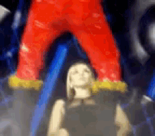 a blurry picture of a woman in a black dress and a red pants