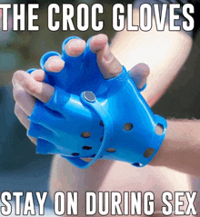 a person wearing a pair of blue croc gloves