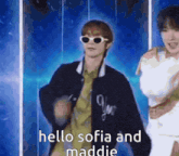 a man wearing sunglasses and a jacket says hello sofia and maddie while dancing .