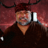 a man with a beard and horns is wearing a red bandana .