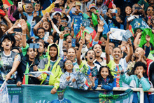 a crowd of people cheering in a stadium with a banner that says winner france