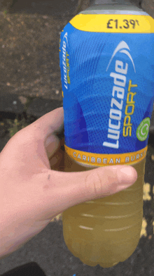 a person is holding a bottle of lucozade sport