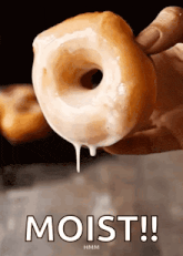 a person is holding a glazed doughnut with the words moist written below it