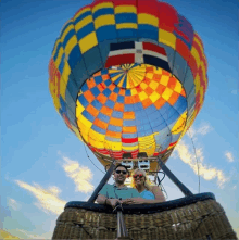 a man and a woman are sitting in a hot air balloon that says ' hot air balloon ' on it