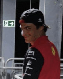 a man wearing a hat and a red shirt is smiling .