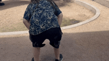 a person wearing a floral shirt and black shorts is squatting down