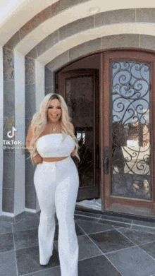 a woman standing in front of a door with tiktok written on the bottom right corner