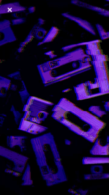 a bunch of cassette tapes are stacked on top of each other in a dark room .