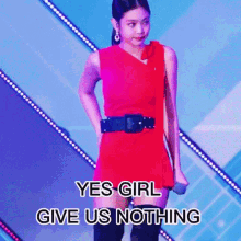 a woman in a red dress is holding a microphone on a stage and says `` yes girl give us nothing '' .