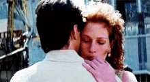 a man and a woman are hugging and kissing in a movie scene .