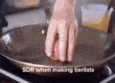 sdr when making tierlists is written above a person 's hand on a pan