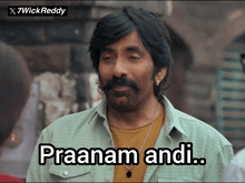 a man with a mustache is wearing a shirt that says praanam andi