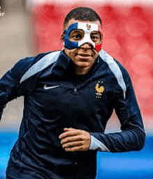 a soccer player is wearing a mask on his face while running on the field .