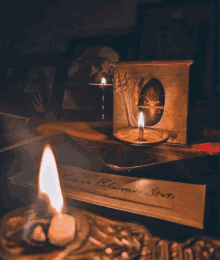 a candle sits on a table next to a piece of paper that says ' longa bharati bruti '