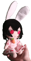 a person is holding a stuffed doll with bunny ears