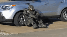 a man in a military uniform sits in front of a silver car with the word props on the bottom