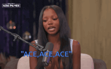 a woman sitting in front of a microphone with the words " ace ace ace " in blue