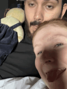 a man with a beard is holding a stuffed animal next to a baby