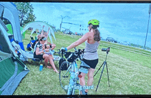 an lg tv screen shows a woman riding a bike and says #sling hard