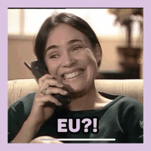 a woman is smiling while talking on a cell phone and the words eu appear below her