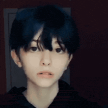 a close up of a person 's face with a black hoodie on .