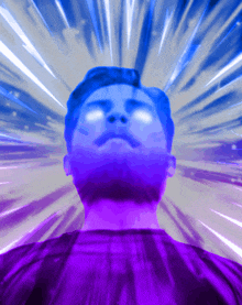 a man 's face is glowing brightly in a purple light