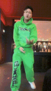 a man wearing a green hoodie and green sweatpants with the word enough on the bottom