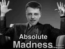 a black and white photo of a man with absolute madness written on the bottom