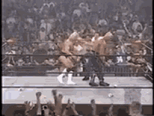 a couple of men are wrestling in a ring with a crowd watching .