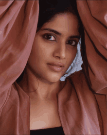 a close up of a woman 's face with a pink cloth covering her face