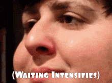 a close up of a man 's face with the words " waiting intensifies " above it