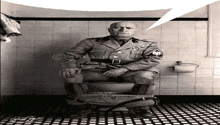 a man in military uniform sits on a toilet with his pants down