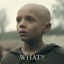 a young boy with a shaved head has the words what written on his face