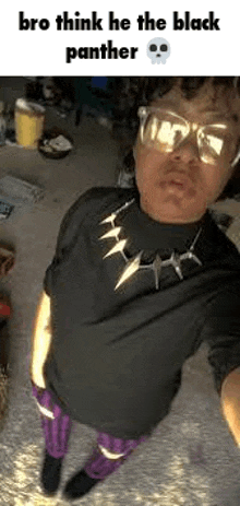 a man is taking a selfie with a black panther necklace on his neck .