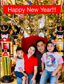 a family posing for a picture in front of a christmas tree with the words happy new year written above them