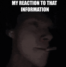 a man is smoking a cigarette in the dark with the words `` my reaction to that information '' above him .