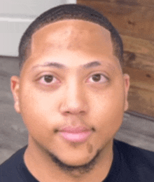 a close up of a man 's face with a black shirt on .