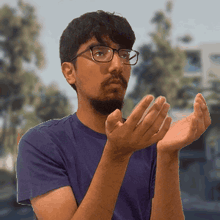 a man wearing glasses is clapping his hands