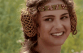 a woman wearing a headband and ear protectors smiles for the camera