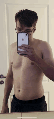 a shirtless man is taking a picture of himself in a mirror