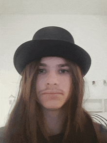 a young man with long hair and a bowler hat