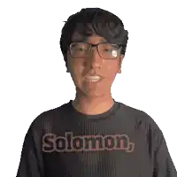 a young man wearing glasses and a solomon shirt