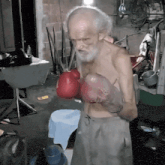 an elderly man wearing red boxing gloves with the letter h on the gloves