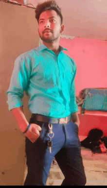 a young man wearing a green shirt and black pants has a key hanging from his belt