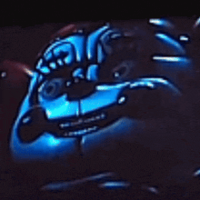 a close up of a cartoon character 's face with glowing eyes and a black background .