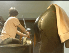 a person holding a sword in front of a black leather chair