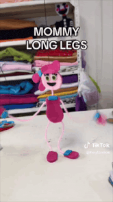 a pink doll with long legs is standing on a table