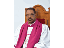 a priest is sitting in a wooden chair wearing glasses and a purple stole